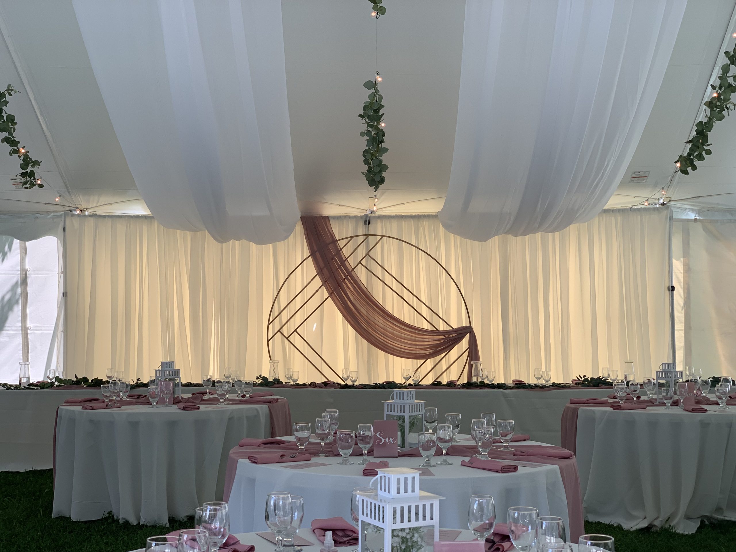 Gorgeous geometric arbour and soft blush linens used as wedding decor.