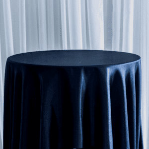 A basic black polyester tablecloth on a round table used for wedding decor.