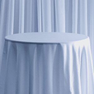 A basic white polyester tablecloth on a round table used for wedding decor.
